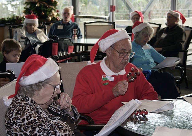 Carolers ring sleigh bells as they sing carols at the Community Center at Mercer View fifth anniversary celebration on Dec. 16. Islanders stopped by to sing