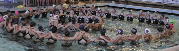 The Mercer Island girls swim and dive team cheer before the team's meet against Bainbridge on Tuesday
