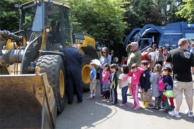 Preschool children line up for a turn to climb into a John Deere tractor during the annual truck day at the Stroum Jewish Community Center on Thursday