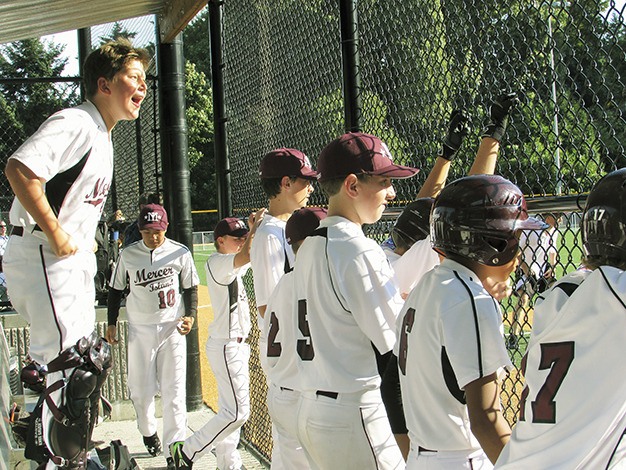 The Mercer Island 11-12 All-Stars cheer on their team from the dugout during the District 9 tournament in July.
