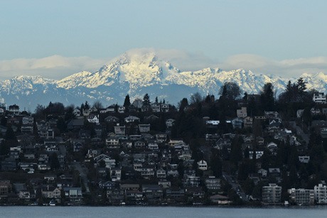 The Olympic Mountain range catches sunlight behind the Leschi neighborhood of Seattle in this western view from Mercer Island on Thursday