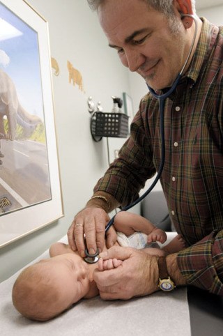 Mercer Island resident and doctor Hal C. Quinn tends to a baby in his office.