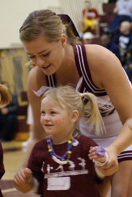 A member of the basketball cheer squad helps a Little Cheerleader during the halftime show of the boys game against West Seattle on Jan. 30.