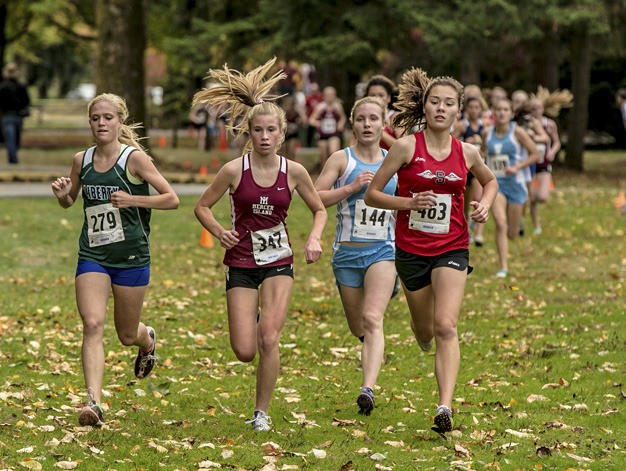 Mercer Island's Alida Scalzo (center) runs with Liberty's Megan Chucka (left)