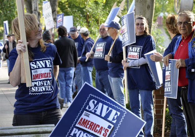 Postal workers representing four employee unions gathered in front of Rep. Dave Reichert's office on Tuesday afternoon