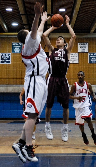 Islander guard Peter Zajac (21) takes a jumpshot over the Juanita defense during KingCo league tournament play at Bellevue Community College on Friday.