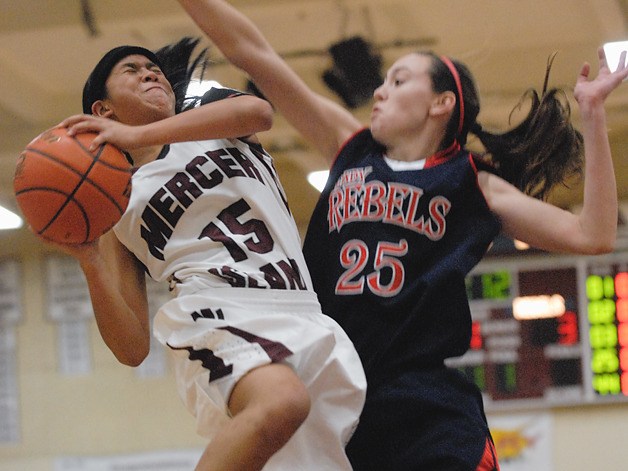 Islander guard Suri Johnson (15) drives and scores against Rebel defender Molly Grager (25) during the first half against Juanita at Mercer Island on Friday.