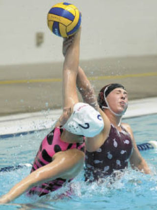 Islander Hayley March goes for a block against a Newport player during last year’s state final at the King County Aquatic Center.
