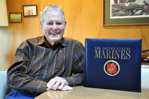 Roy Mays at home on Mercer Island with his book of personal World War II documents and photos.