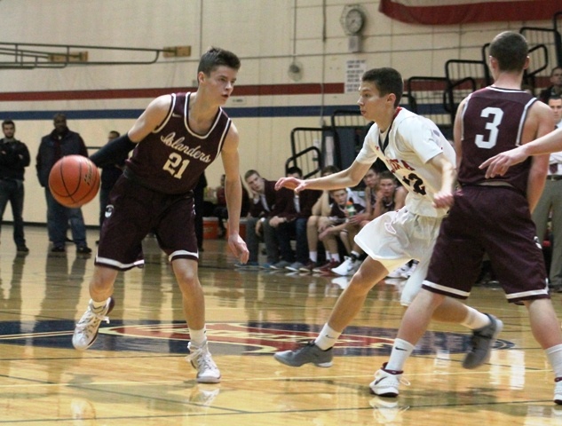 Mercer Island's Shain Scott (21) evades Juanita defender Danny Eason off a pick from teammate Josh Stenberg (3) during the first half of the Islanders' game against the Rebels Tuesday