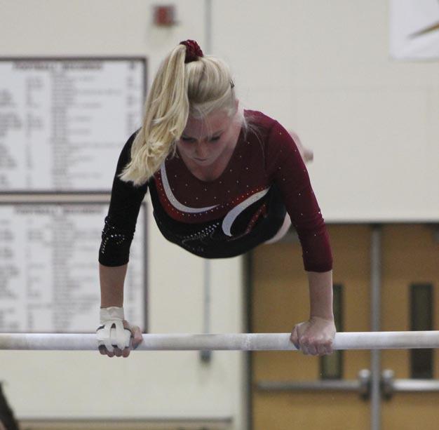 Mercer Island's Molly Goldberg competes in the bars competition during the Islanders home meet against Lake Washington and Interlake on Thursday