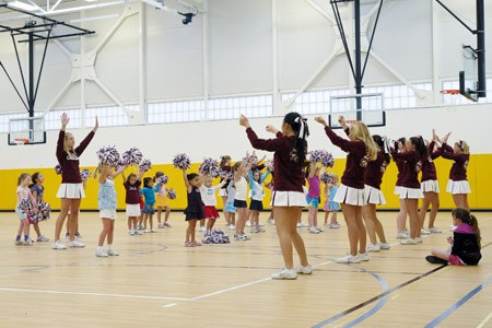Members of the Mercer Island High School cheerleading squad direct young cheerleaders-to-be during the Mercer Island Boys and Girls Club cheerleading camp. The camp was held in the new PEAK building.