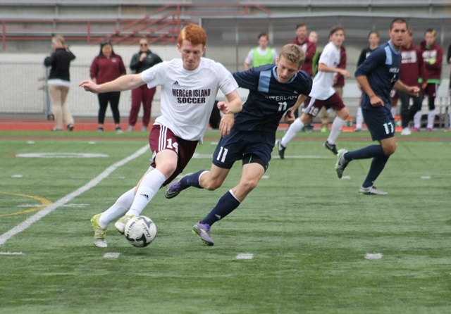 Mercer Island's Austin Taylor charges past Interlake's Daniel Pratt during the 3A boys soccer state championship Saturday at Sparks Stadium in Puyallup. The Saints beat the Islanders 1-0.