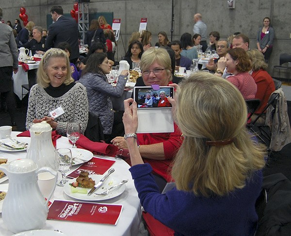 Deputy Mayor Debbie Bertlin takes a photo of her guests at the Giving from the Heart  breakfast on Feb. 10. The annual fundraiser for Youth and Family Services has raised about $220