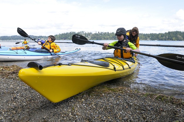 Islander youth take kayaking lessons along the shore of Lake Washington at Luther Burbank Park.