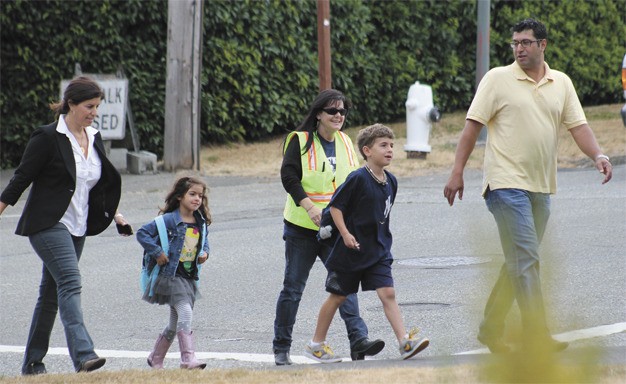 David and Shauna Youssefnia cross the street with their children Max