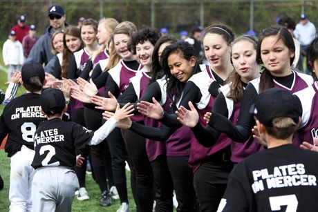 The Mercer Island High School girls fastpitch team greets Little League teams during the Little League Opening Day ceremony on Saturday