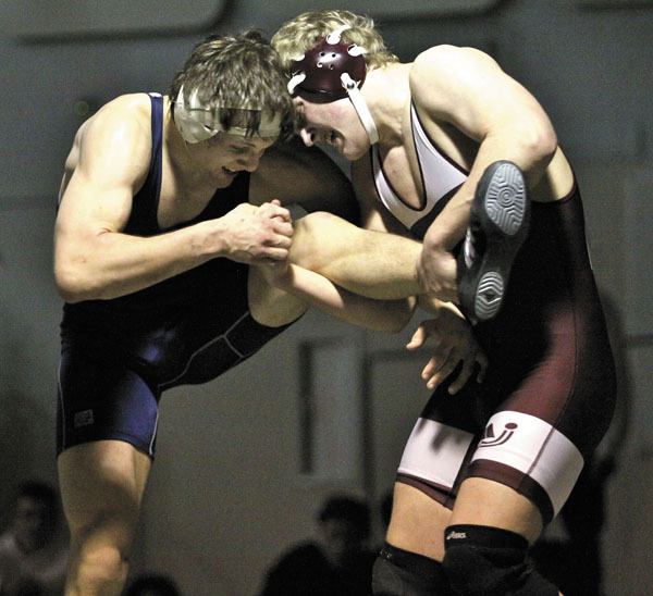 Phil Frazier secures the leg of Juanita’s Logan McCallum during overtime of the 171-pound championship bout.