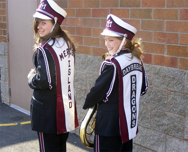Two girls with the Daybreak Middle School marching band show off their 'new' uniforms purchased from Mercer Island High School. The band is now raising money to replace the 'Mercer Island' on the back with 'Daybreak Dragons