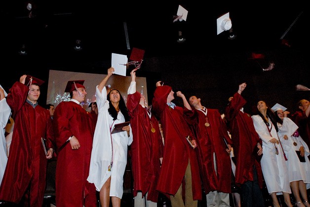 Seniors toss their caps in the air to end the Mercer Island High School graduation ceremony at the Meydenbauer Center in Bellevue on Thursday.