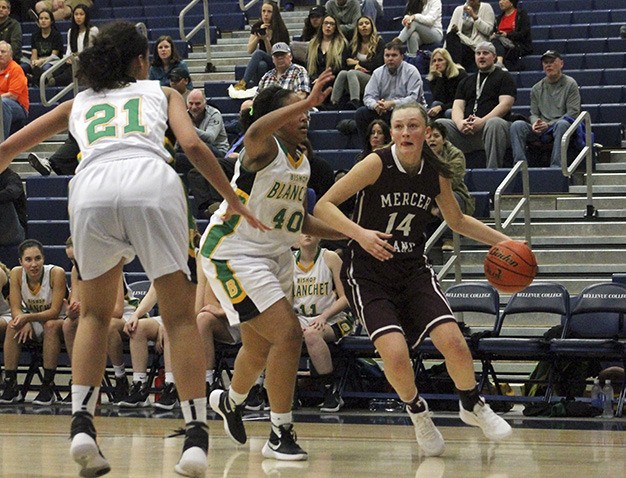 Mercer Island's Jess Blakeslee (14) drives around Bishop Blanchet's Bella Kemp (40) and Jadyn Bush (21) Thursday night at Bellevue College. The Braves beat the Islanders 58-53.