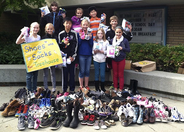 Members of the West Mercer Student Council display some of the dozens of pairs of shoes and bundles of socks that they have collected to send to children at Treehouse in Seattle.