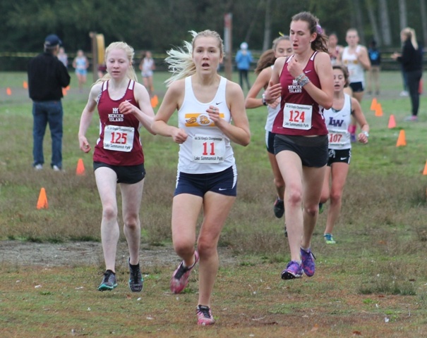 Mercer Island's Cece Rosenman (125) and Chloe Michaels (124) flank Bellevue's Casey Jacobson (11) during the girls 5K at the 3A KingCo Championships Saturday