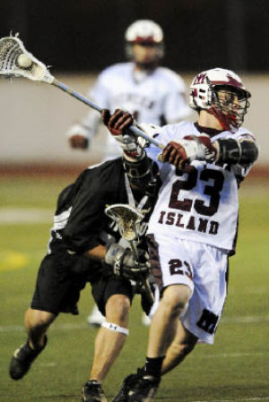 Islander Steven Caditz takes a shot against Puyallup on Tuesday at Islander Stadium. Both the boys and girls lacrosse teams were in action last week. For the full stories