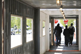 Pedestrians walk through a temporary sidewalk tunnel along the 7800 Central construction project on Mercer Island.