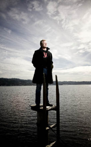 Island attorney Lory Lybeck takes a superhero stance on a piling in Lake Washington near his Island home in this photo that ran in BusinessWeek magazine.