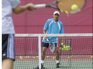 Islander Ryan Pang coaches one of his students at the MIHS courts.