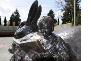 A statue of a boy with a book and rabbit sits at the Island library.