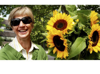 Islander Lori Langston gathers a bouquet of sunflowers at the Mercer Island Farmers Market. See more photos on page A9.