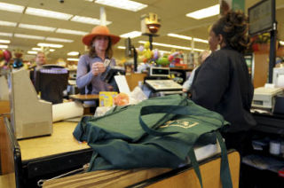 Islander Frances Gaul’s reusable cloth bags wait to be filled as cashier Linda Phillips rings up her groceries at the North-end QFC on Mercer Island