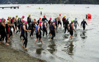 Participants from the 2005 Escape from the Rock Triathlon enter the cold waters of Lake Washington for the start of the race.