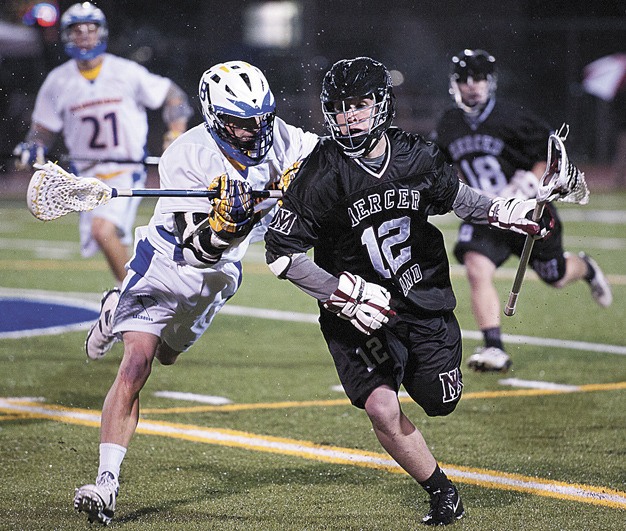 Mercer Island's Hayden Reisman (12) is chased down by a Bainbridge midfielder in Saturday's 'Island War' prep lacrosse rivalry. The Islanders captured their fifth consecutive win over Bainbridge with an 11 - 7 victory at Bainbridge Stadium.