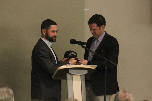 Longtime Mercer Island boys lacrosse coach Ian O’Hearn (left) passed his coaching cap to successor Chris Long at the Mercer Island Lacrosse Club’s auction March 11 at the Community and Event Center (Joe Livarchik/staff photo).