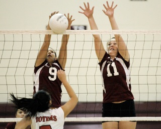 Islanders Ally Bray (9) and Samantha Ruesch (11) set a block against the Sammamish Totems.