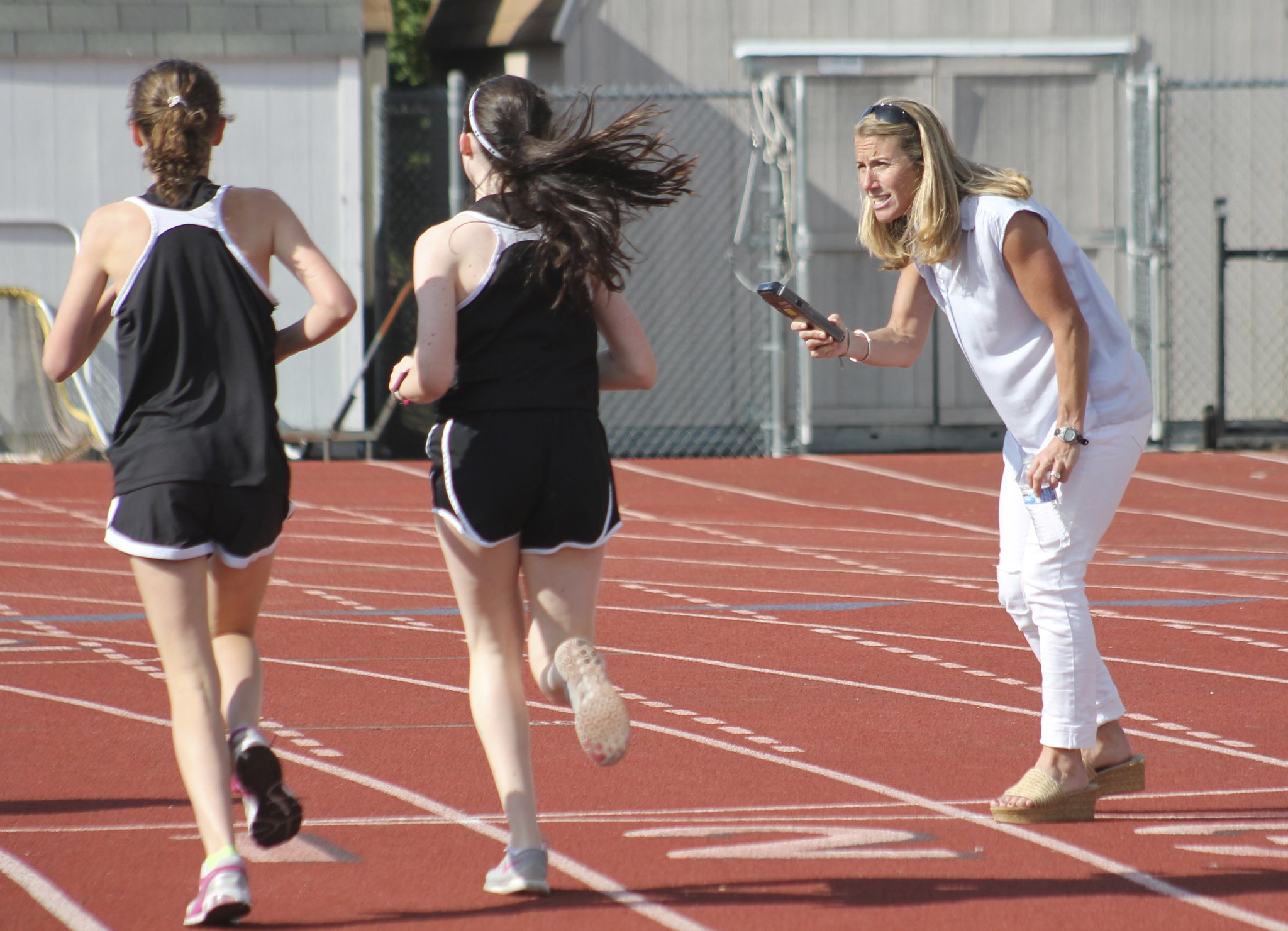 Mercer Island track co-head coach Erica Hill calls out times to runners during Mercer Island’s track meet against Juanita May 5 at Mercer Island High School. At season’s end