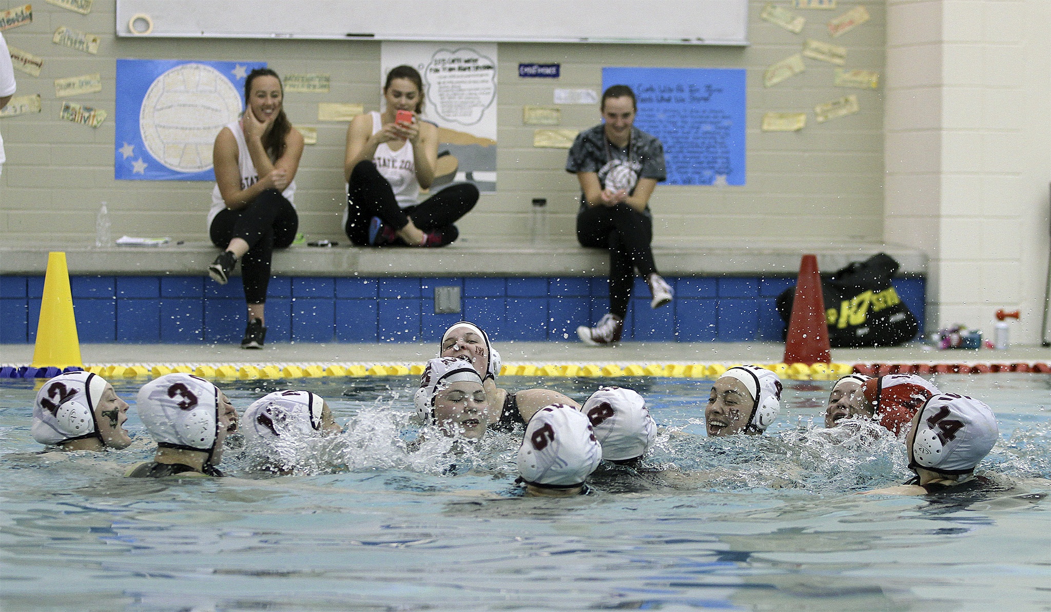 The Mercer Island girls water polo team engages in a halftime cheer during the state tournament
