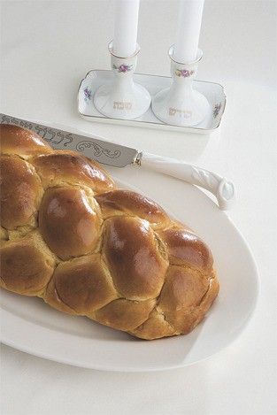 Homemade braided challah bread is served with a traditional Shabbat meal.