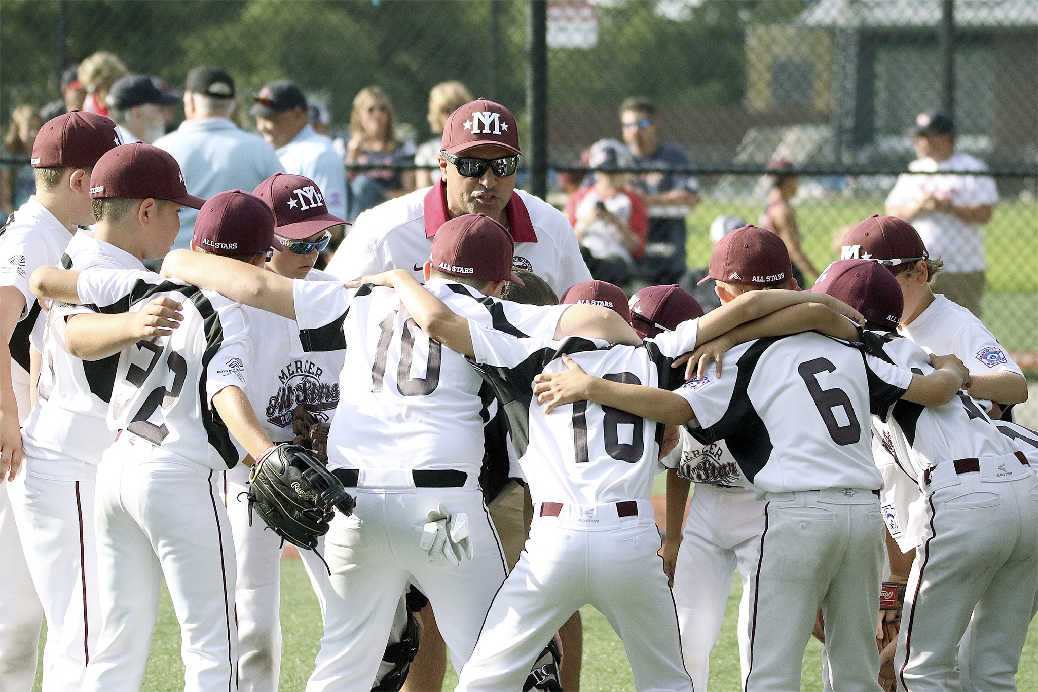 Manager Mak Abulhosn (center) huddles with the Mercer Island 9-10 All-Stars during the District 9 tournament. Photo courtesy of Kim Alex.