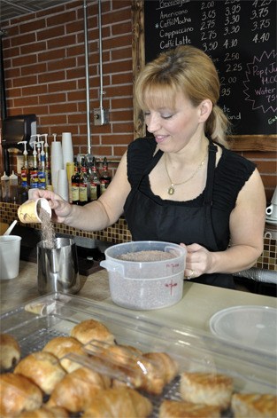 Stacy Alishio measures out ingredients for a drink at Franky & Dom’s Cafe.