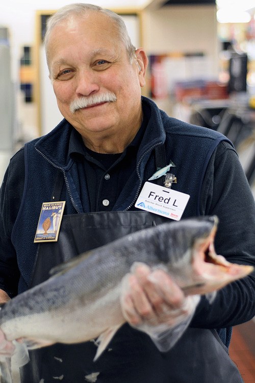 Fred Lenze holds a wild sockeye salmon in the fish department at Albertsons on Mercer Island.