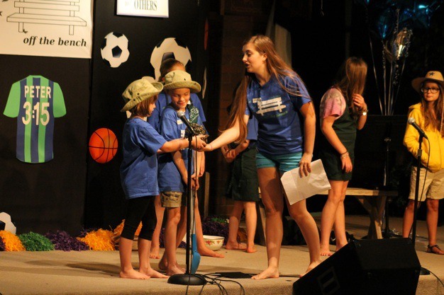 Narrator Julia Congdon gives a treasure chest to children during a skit titled 'The Kingdom Of Heaven Is Like...' as part of Vacation Bible School at the Mercer Island Covenant Church on Thursday