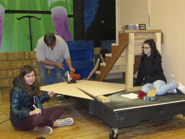 West Mercer teacher Tom Tivnan helps students with the castle stairs as they build sets for “Beauty and the Beast Jr.”