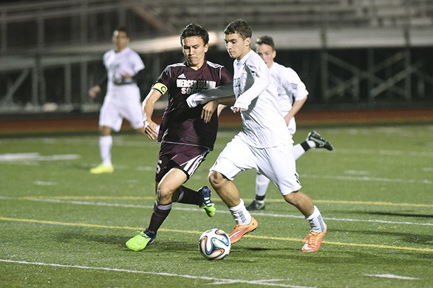 Mercer Island’s Derek Sims works on fending off a Skyline drive during the Islanders’ 2-2 tie with the Spartans Friday
