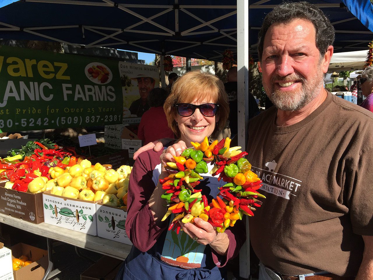 Retiring market manager Patty Spahr poses with her husband at the Mercer Island Farmers Market. Contributed photo
