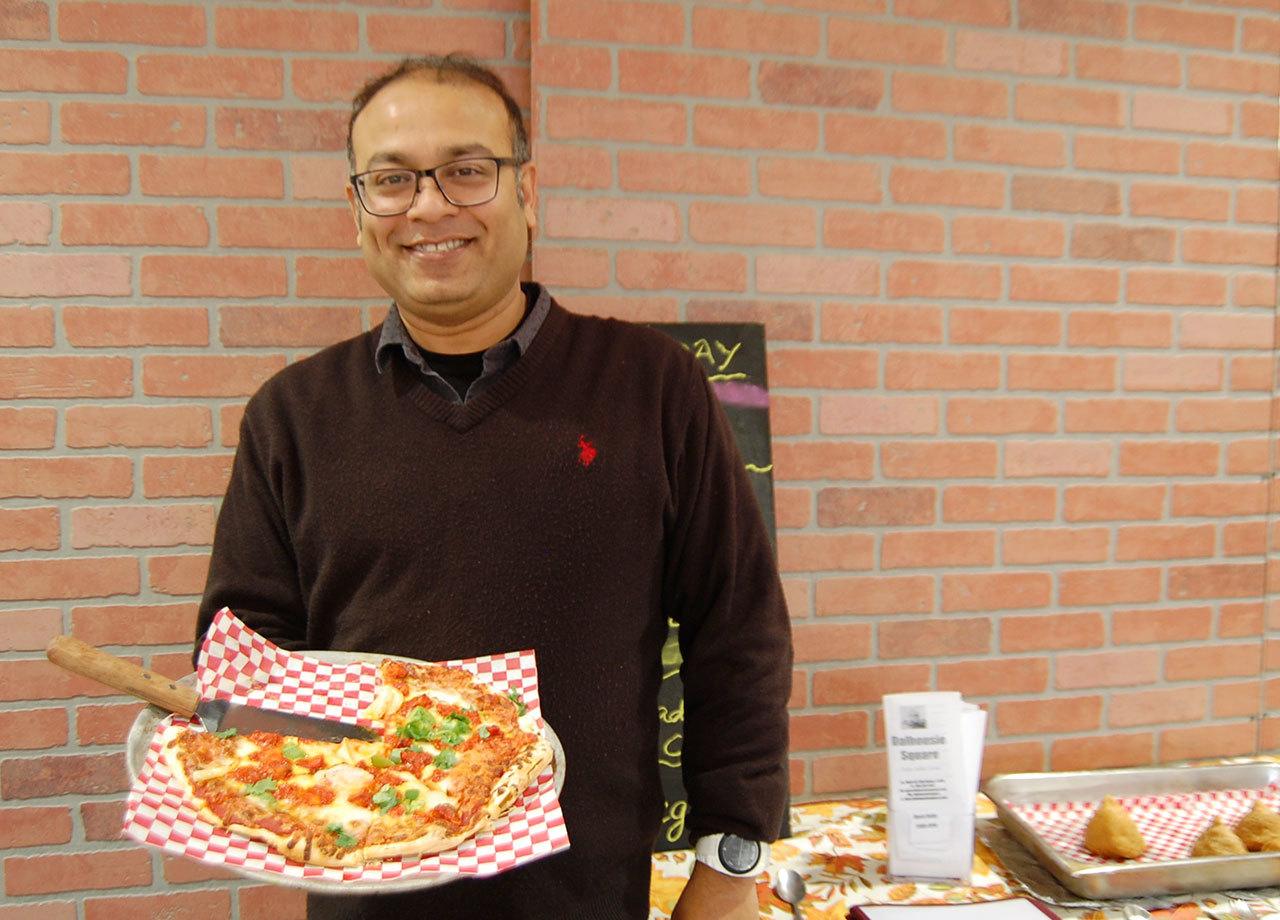 Jish Nath holds a tandoori chicken pizza, one of the dishes on both his Indian and Italian menus at Dalhousie Square and Roberto’s. Katie Metzger/staff photo