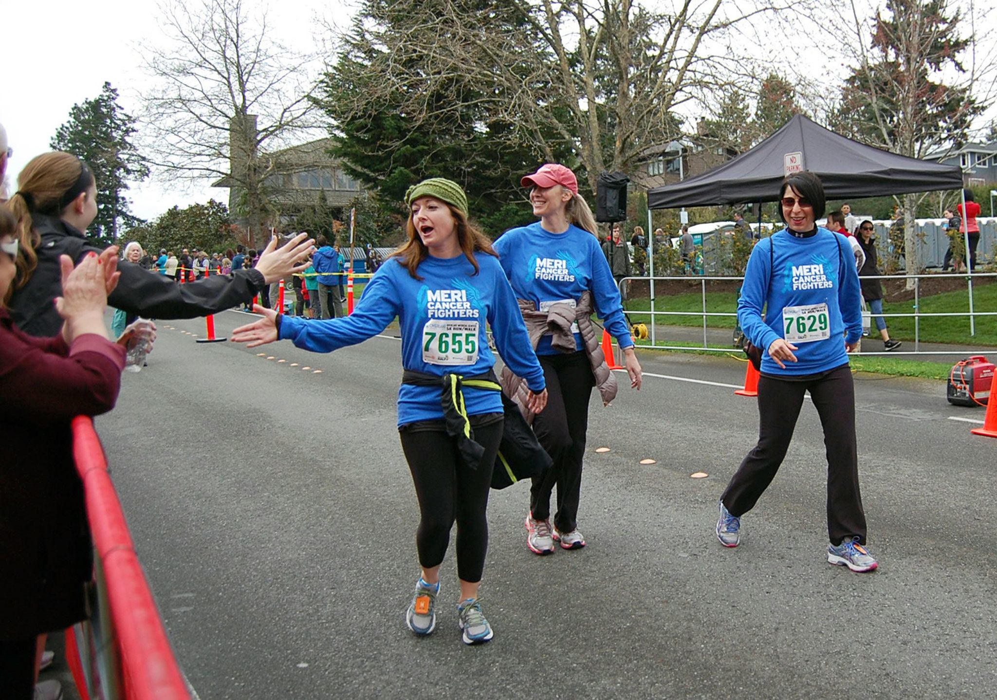 Runners get high-fives as they cross the finish line and complete the 5K at the Mercer Island Rotary Half on March 20. Katie Metzger/staff photo